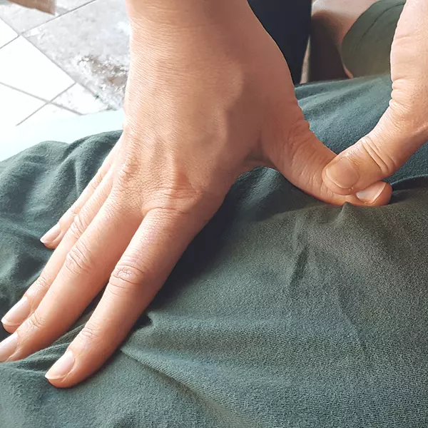 Manos aplicando masaje típico japonés Shiatsu, clínica Laurisilva